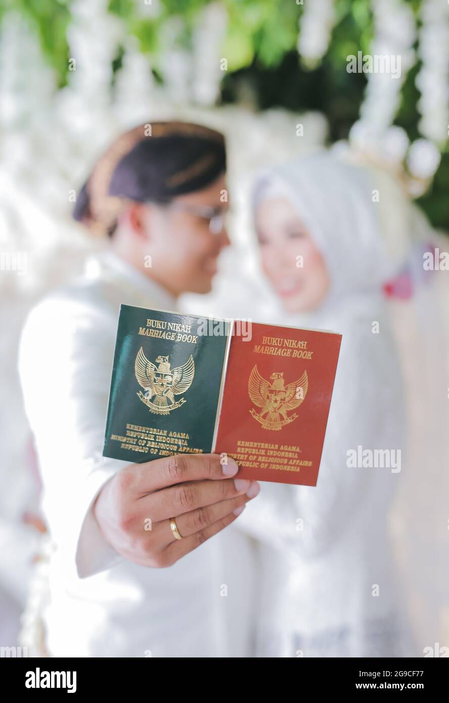 Une attention sélective des nouveaux mariés indonésiens avec leur livre de mariage Banque D'Images