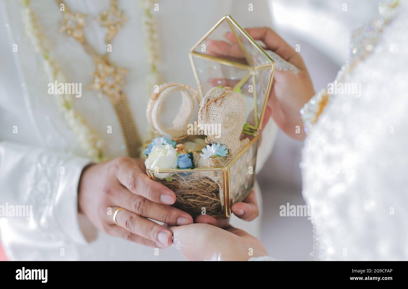 Un petit foyer d'un marié donnant un cadeau symbolique à sa mariée lors  d'une cérémonie de mariage en Indonésie Photo Stock - Alamy