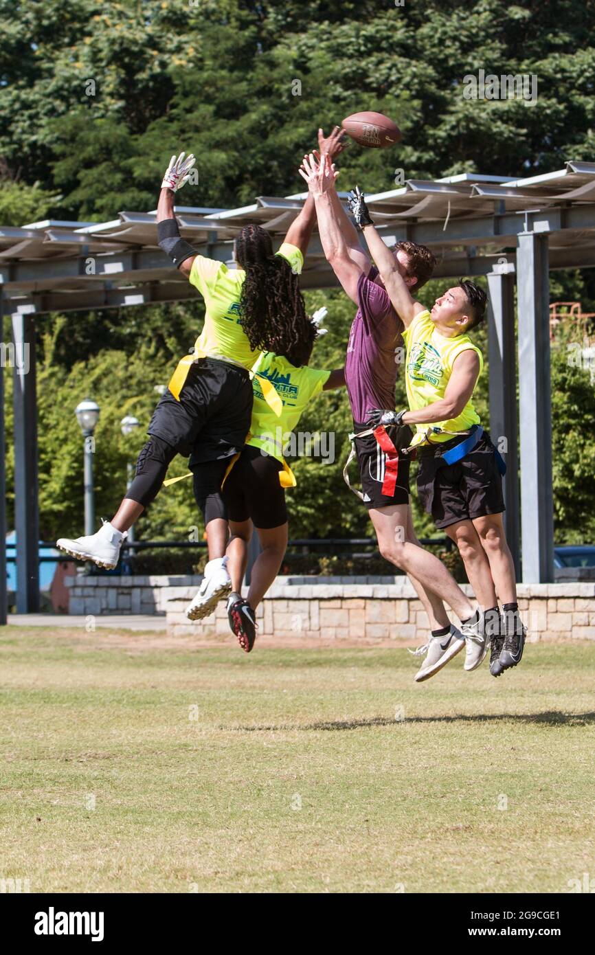 Atlanta, GA, USA - 1 juin 2019 : les hommes jouant à un match de football de drapeau de loisir sautent à l'unisson pour attraper ou défendre un pass. Banque D'Images