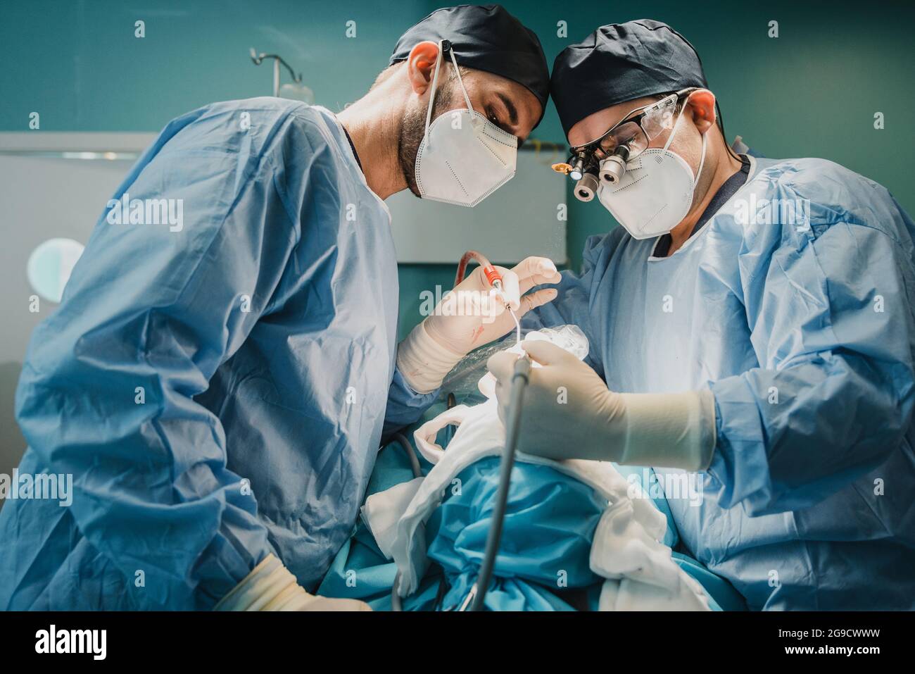 Médecins équipe d'opération de patients en salle chirurgicale à l'hôpital - Focus sur les visages de chirurgiens Banque D'Images