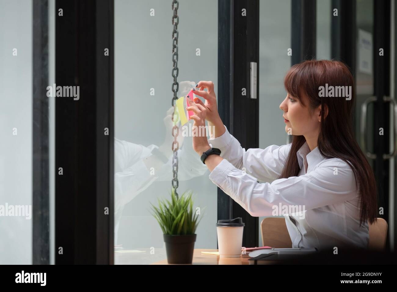 Femme d'affaires publier des notes d'idée discuter et la planification dans mur de verre, Business Financial concept. Banque D'Images