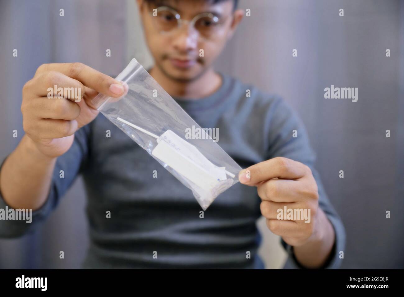 L'homme ramasse les déchets infectés par la machine de test Covid-19 dans un joli sac à glissière pour les détruire correctement.après utilisation, l'auto-test Covid-19 (test rapide d'antigène) se Banque D'Images