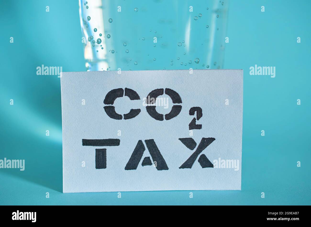 Un verre d'eau pétillante et une carte avec l'inscription taxe carbone Banque D'Images Un verre d'eau pétillante et une carte avec l'inscription taxe carbone Banque D'Images