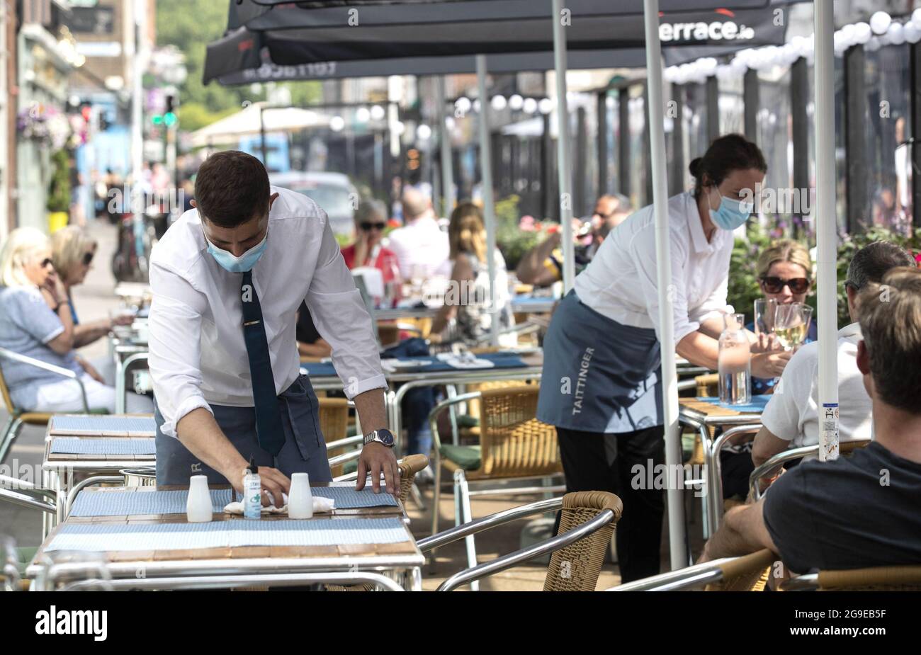 Photo du dossier datée du 23/07/21 d'un serveur qui a installé une table à l'extérieur du restaurant Hugo sur Merrion Row à Dublin. La restauration intérieure dans les pubs et les restaurants rouvrira aujourd'hui en Irlande, ce qui marque une étape importante pour le secteur de l'accueil. Date de publication : lundi 26 juillet 2021. Banque D'Images