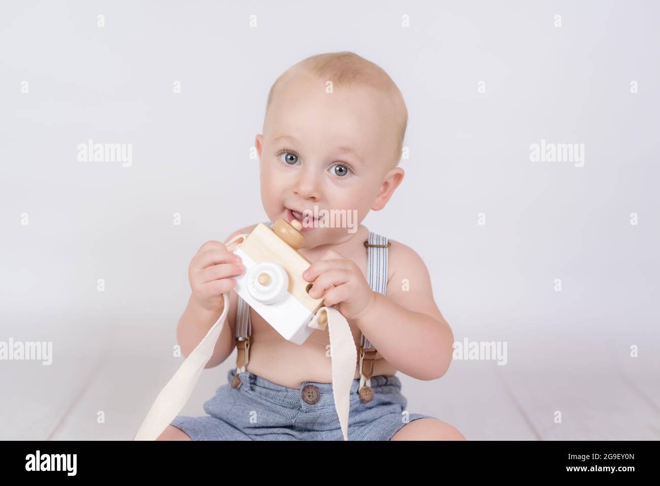 petit garçon avec un ancien appareil photo sur fond blanc Banque D'Images