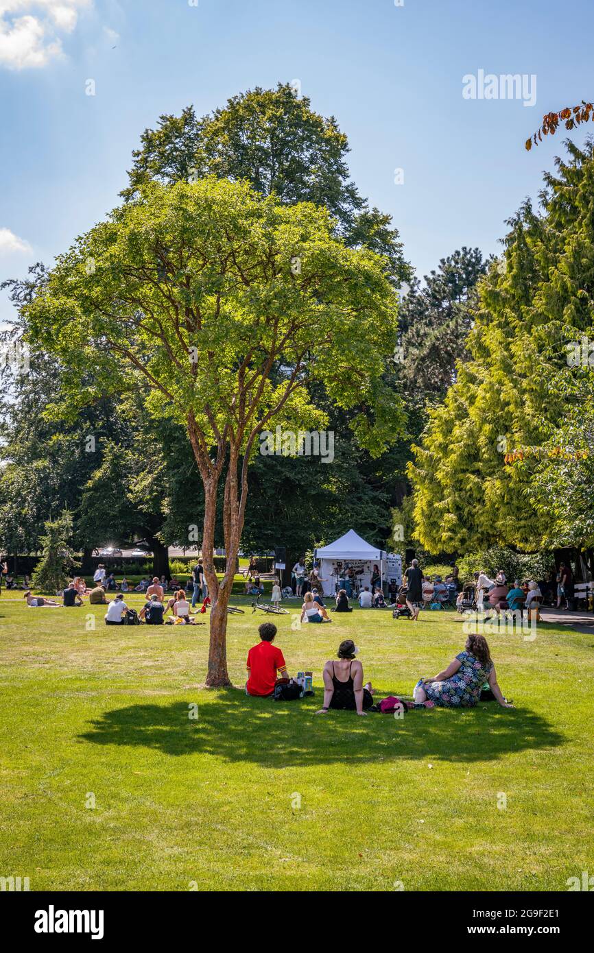 Un groupe de personnes prend de l'ombre sous un arbre lors du festival Worcester's Band in the Park, été 2021 Banque D'Images