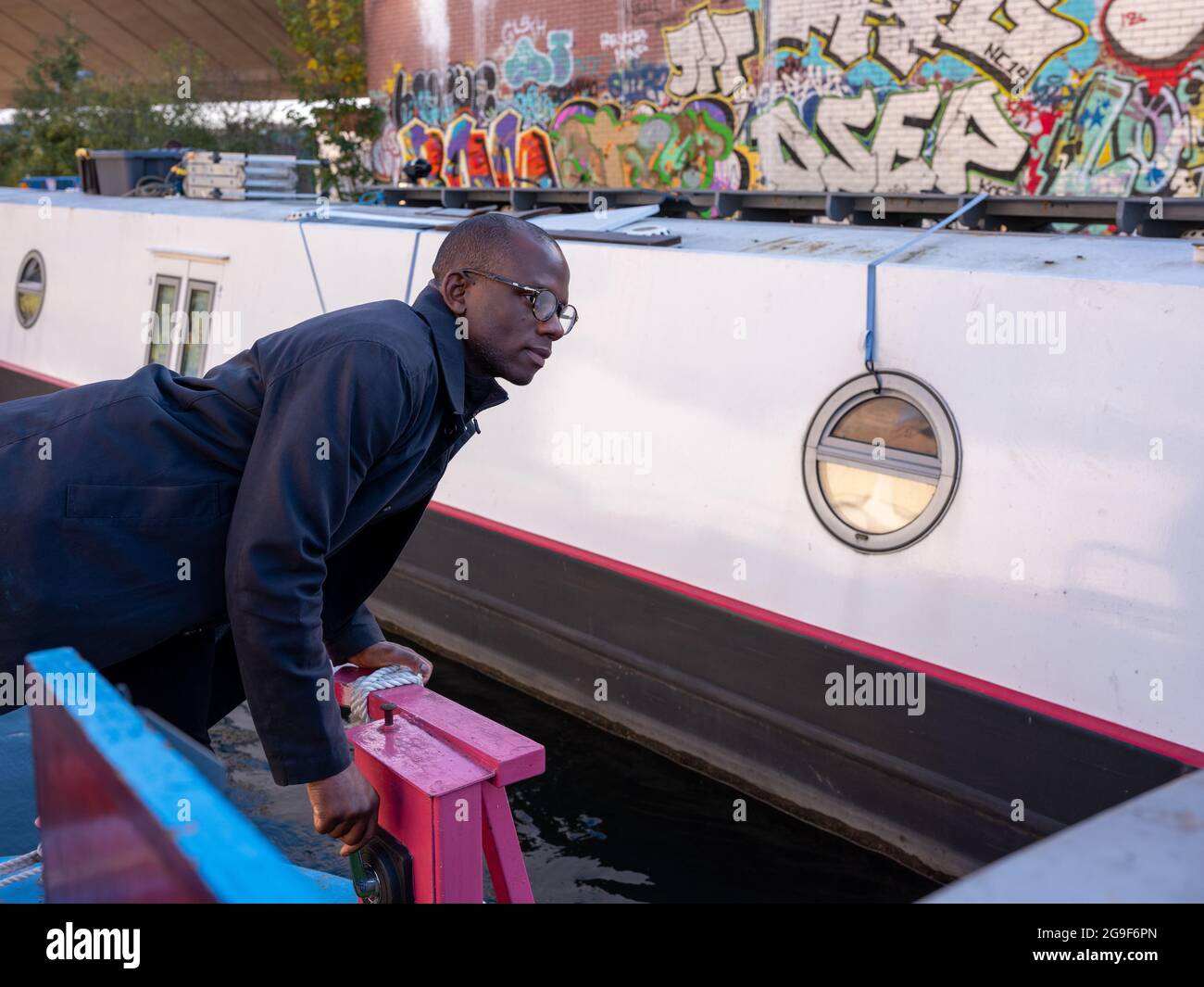 Un noir nouant un bateau étroit le long du canal Regent's à Little Venice, Londres Banque D'Images