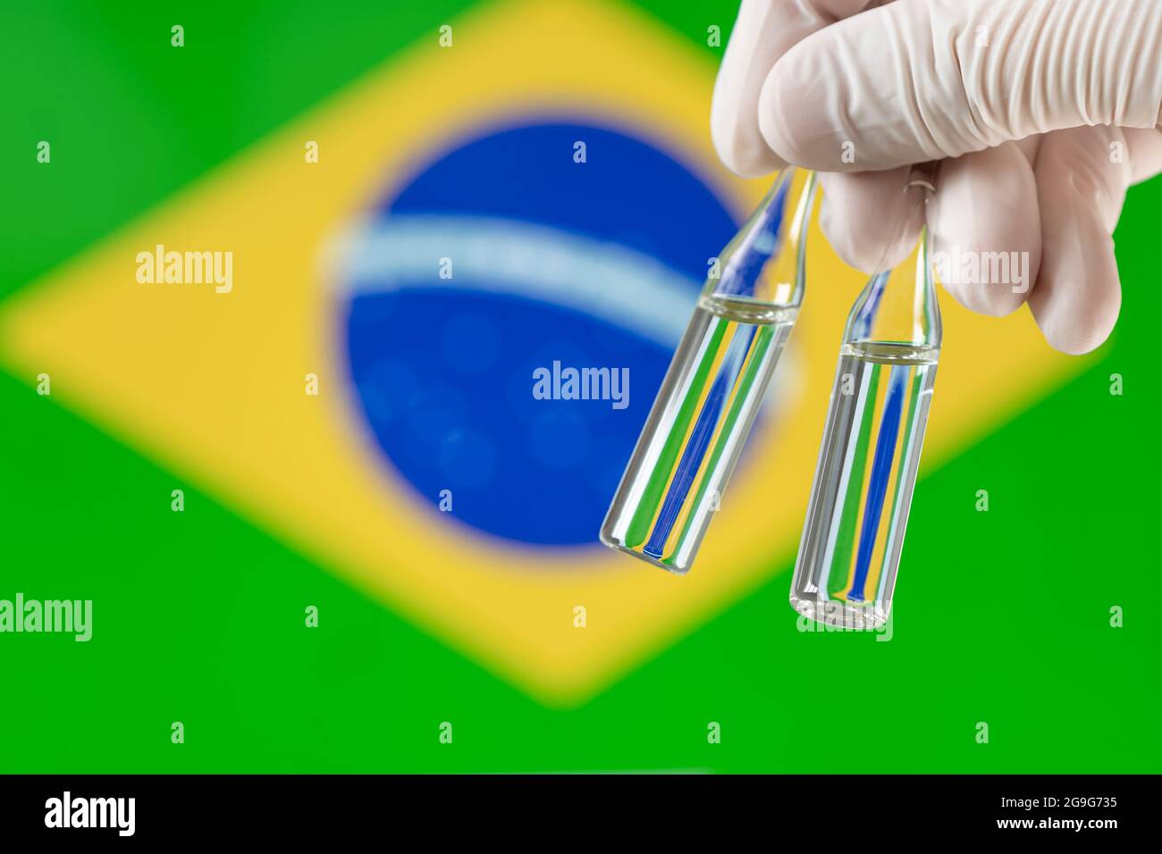 Médecin tenant le vaccin du coronavirus dans sa main. Vaccin du coronavirus avec le drapeau du Brésil en arrière-plan. Brésil recherche médicale et développement de vaccins Banque D'Images