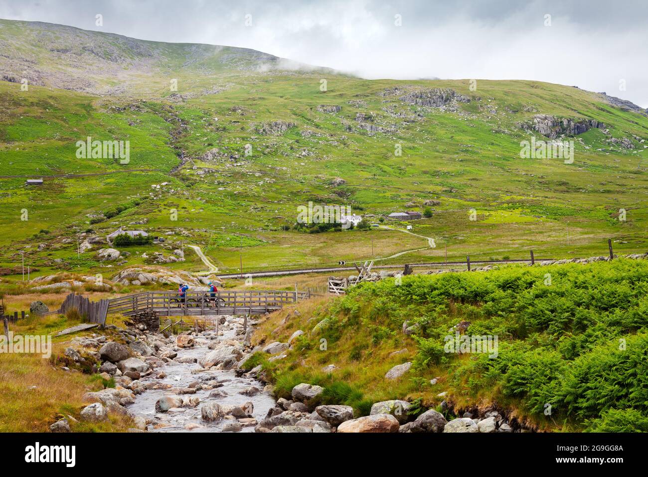 Marchez de Gwern gof Ichaf à Llyn Ogwen, avec deux cyclistes sur le pont Banque D'Images