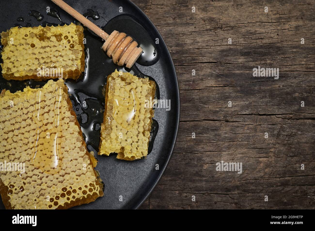 Gros plan nid d'abeilles et balancier au miel sur une table en bois Banque D'Images