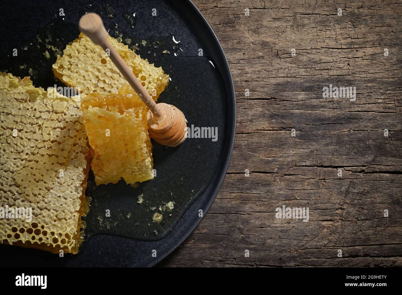 Gros plan nid d'abeilles et balancier au miel sur une table en bois Banque D'Images