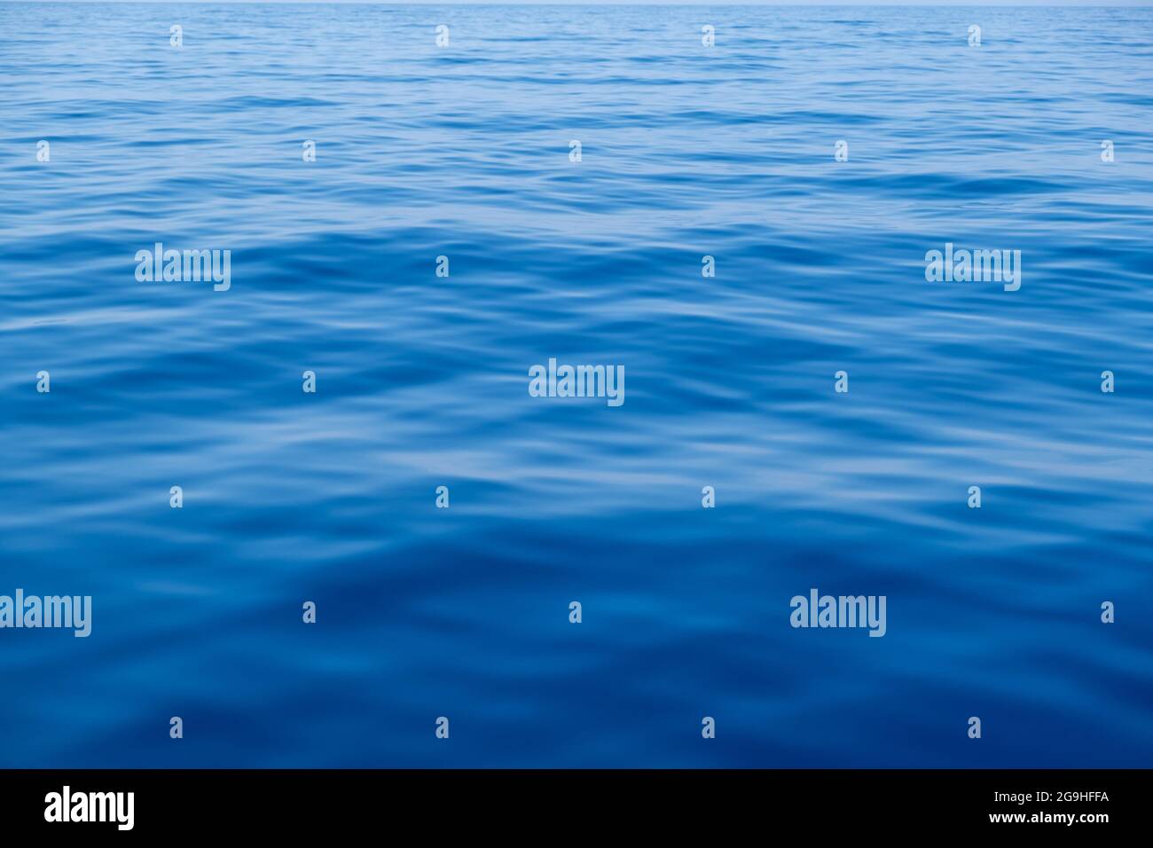 La surface de l'eau de mer est calme avec de petites ondulations. Océan fixe, fond bleu foncé, texture. Espace Banque D'Images