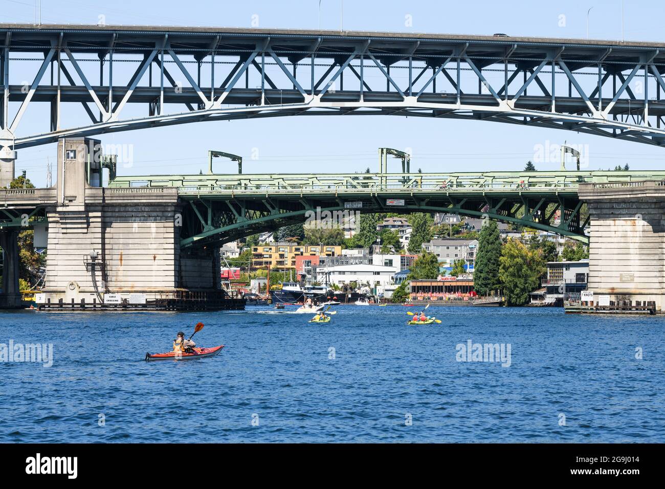 Seattle - 25 juillet 2021 ; les utilisateurs de kayak et de bateau à moteur profitent d'une journée d'été à Seattle en passant sous le pont de l'université et le pont du canal des navires Banque D'Images