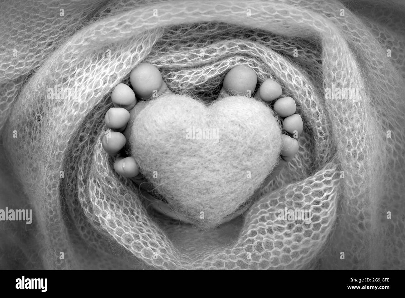 Pieds D Un Nouveau Ne Avec Un Coeur En Bois Enveloppes Dans Une Couverture Souple Noir Blanc Photo Stock Alamy