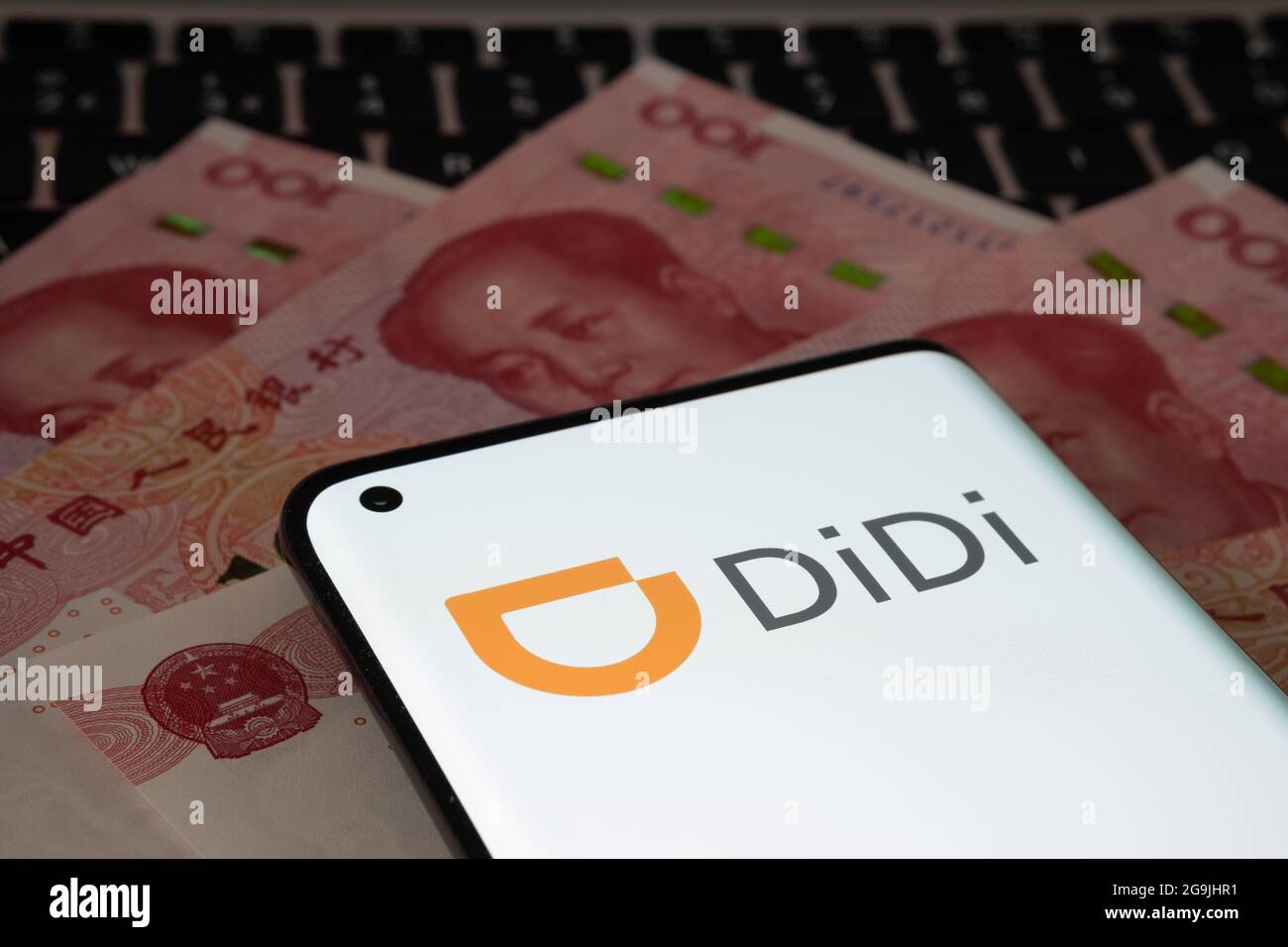 Logo de la société Didi Chuxing Technology vu sur smartphone placé sur des billets de 100 yuans. Concept. Stafford, Royaume-Uni, 26 juillet 2021. Banque D'Images