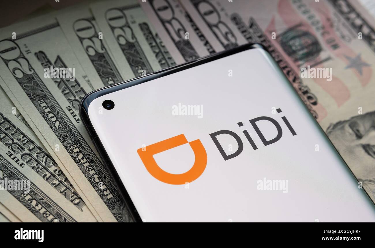 Logo de la société Didi Chuxing Technology vu sur smartphone placé sur pile de dollars américains. Concept. Stafford, Royaume-Uni, 26 juillet 2021. Banque D'Images