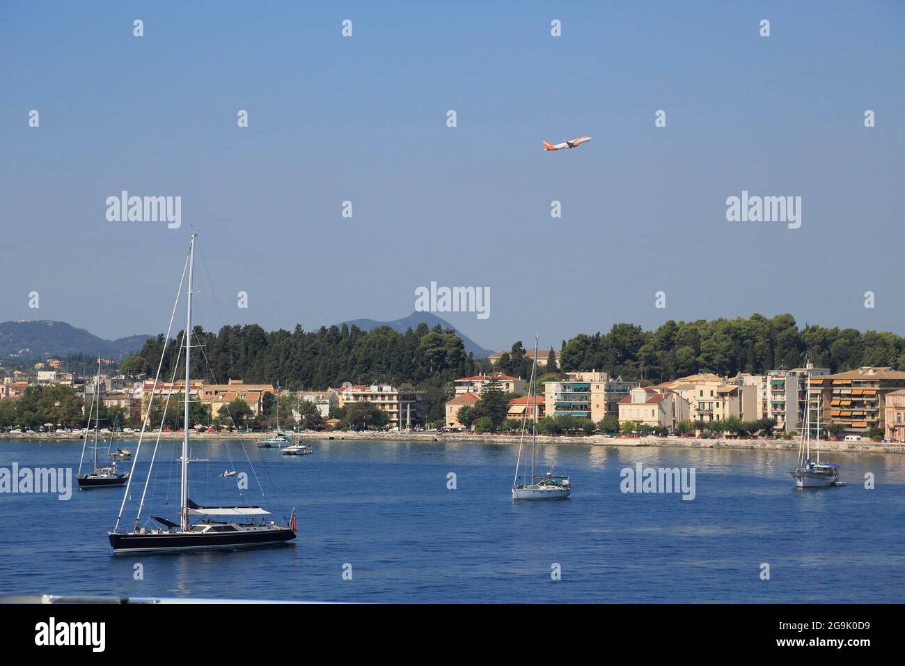 Yachts à voile à l'ancre en face de la ville de Corfou ou de Kerkyra, avion au départ de l'aéroport de Corfou, l'île de Corfou, les îles Ioniennes, la mer Méditerranée Banque D'Images