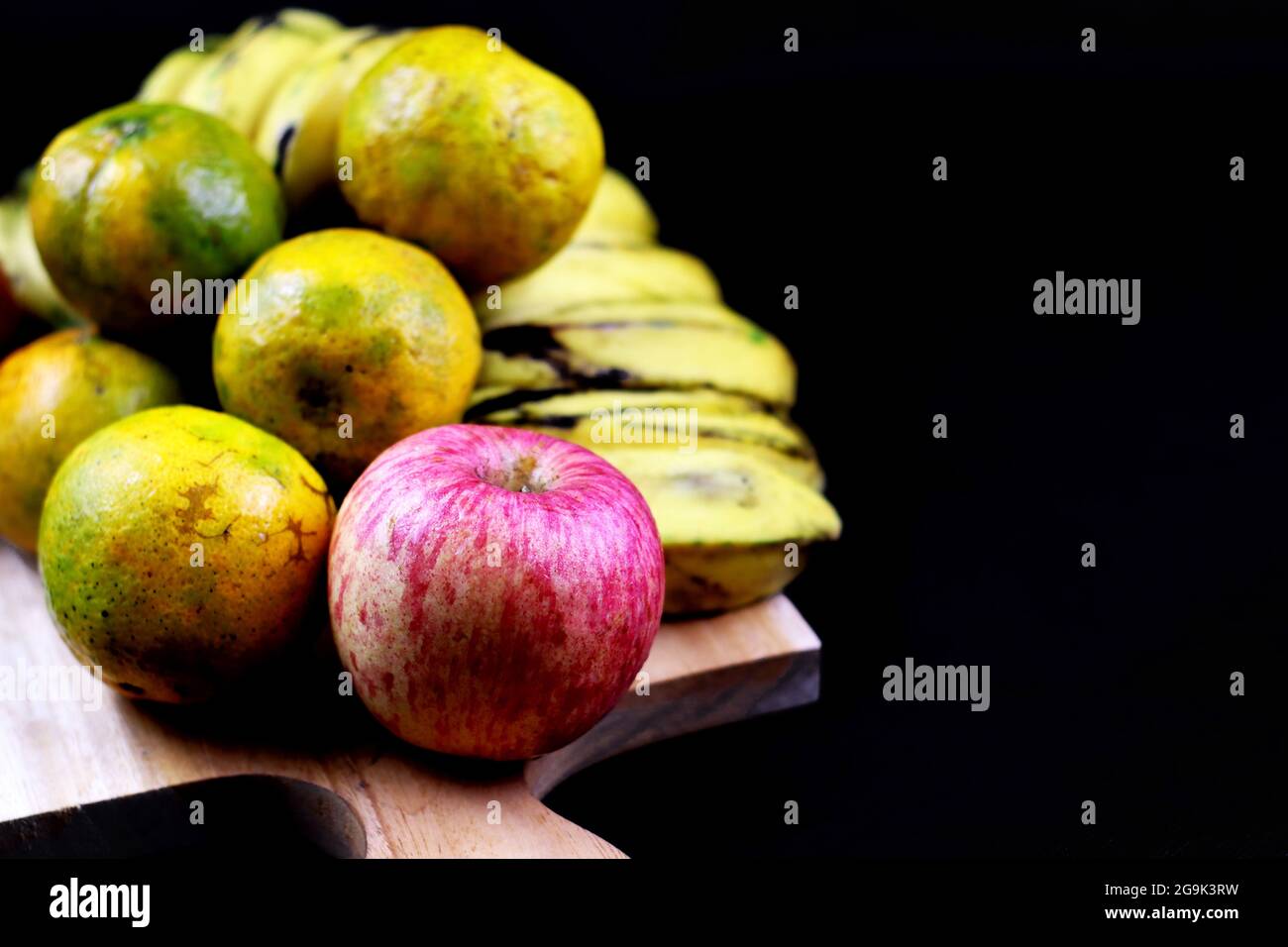 Image de pomme concentrée en groupe de fruits sur la planche à découper avec fond noir Banque D'Images