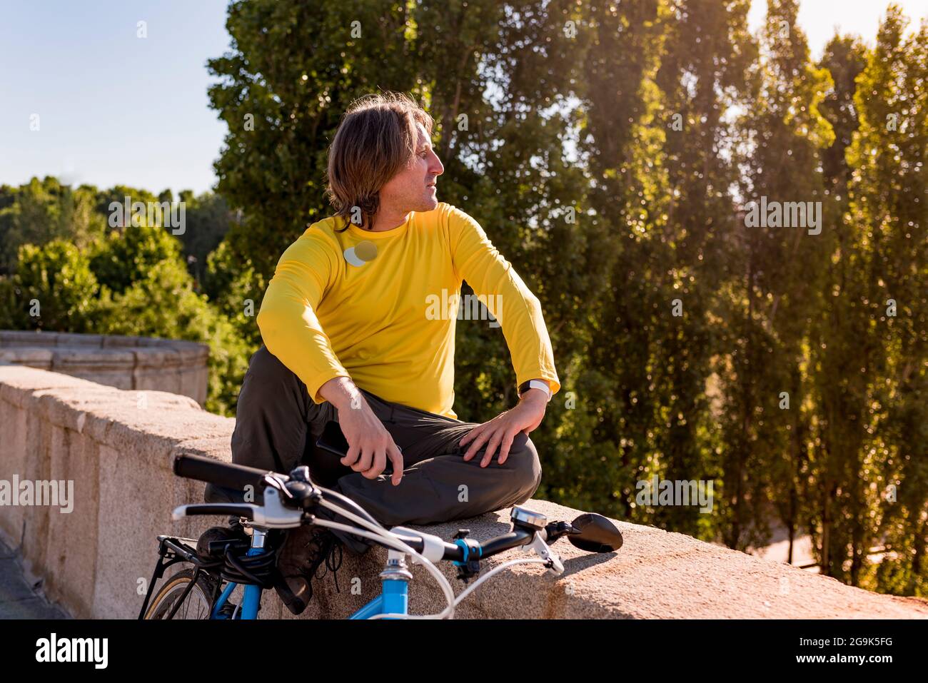 Homme caucasien avec mobile et vélo dans la ville Banque D'Images