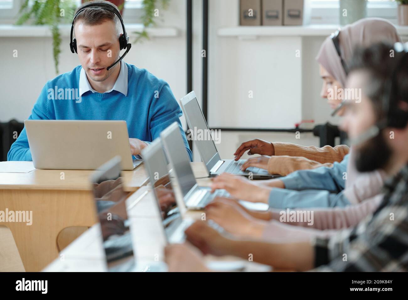 Homme d'affaires sérieux consultant des clients en ligne dans l'environnement de travail au bureau Banque D'Images