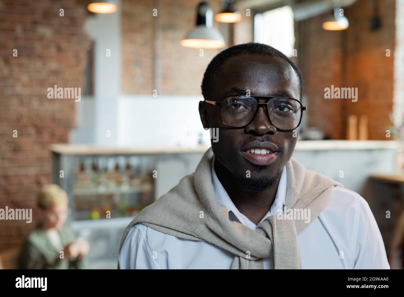 Homme d'affaires africain confiant dans des lunettes debout devant l'appareil photo Banque D'Images