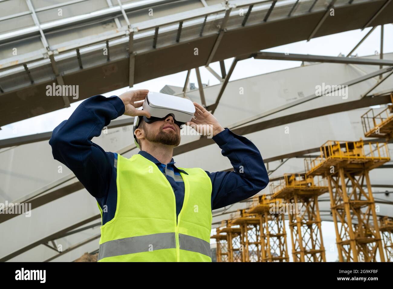 Jeune ingénieur utilisant des lunettes de réalité virtuelle dans son travail il travaille sur le chantier de construction Banque D'Images