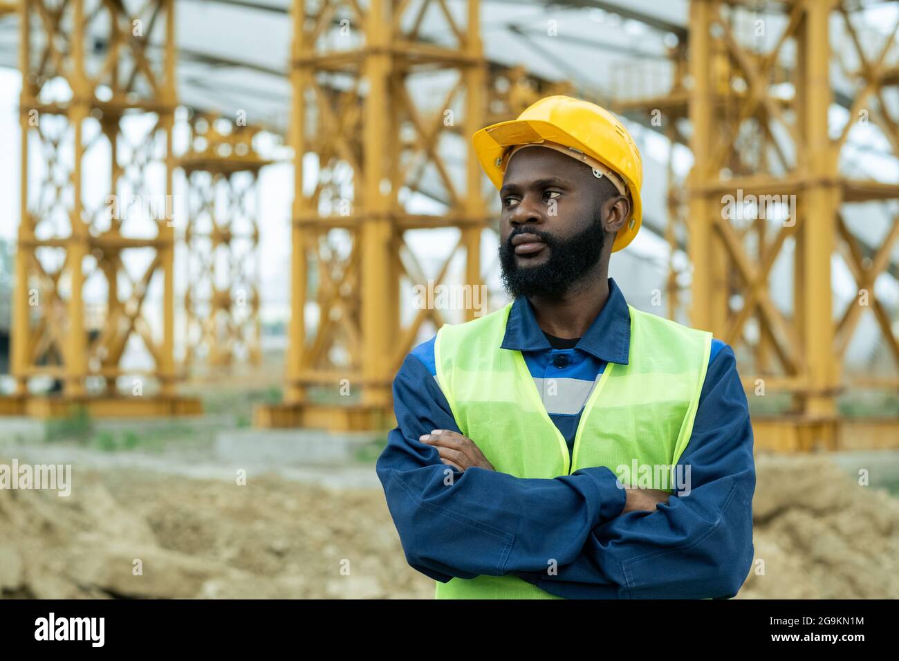 Un ouvrier de la construction africain en casque de travail debout avec ...