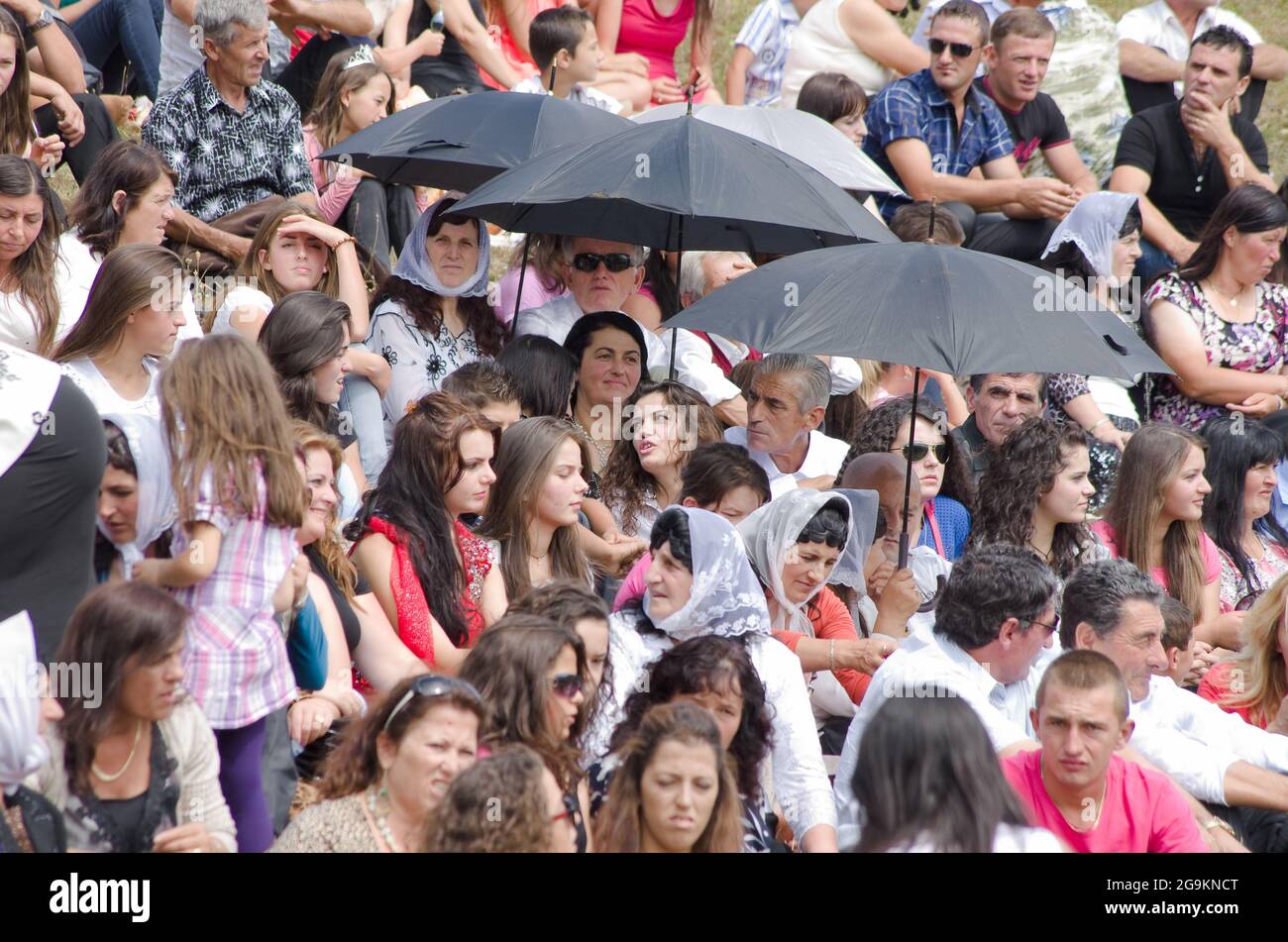 Lepushe, Albanie - 11 août 2012 : la foule assemblée siège au 'Highlanders Festival 2012' (albanais : Logu i Bjeshkëve) certaines personnes protègent le thème Banque D'Images