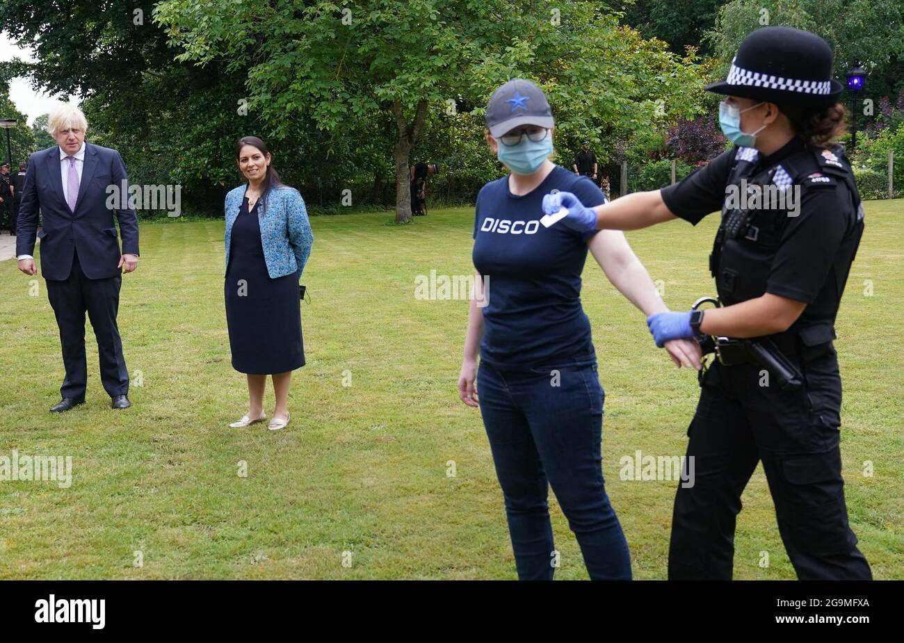 Le Premier ministre Boris Johnson et le secrétaire d'État à l'intérieur, Priti Patel, regardent un exercice de recherche au cours d'une visite au quartier général de la police de Surrey à Guildford, dans le Surrey, pour coïncider avec la publication du Plan de lutte contre le crime du gouvernement. Date de la photo: Mardi 27 juillet 2021. Banque D'Images