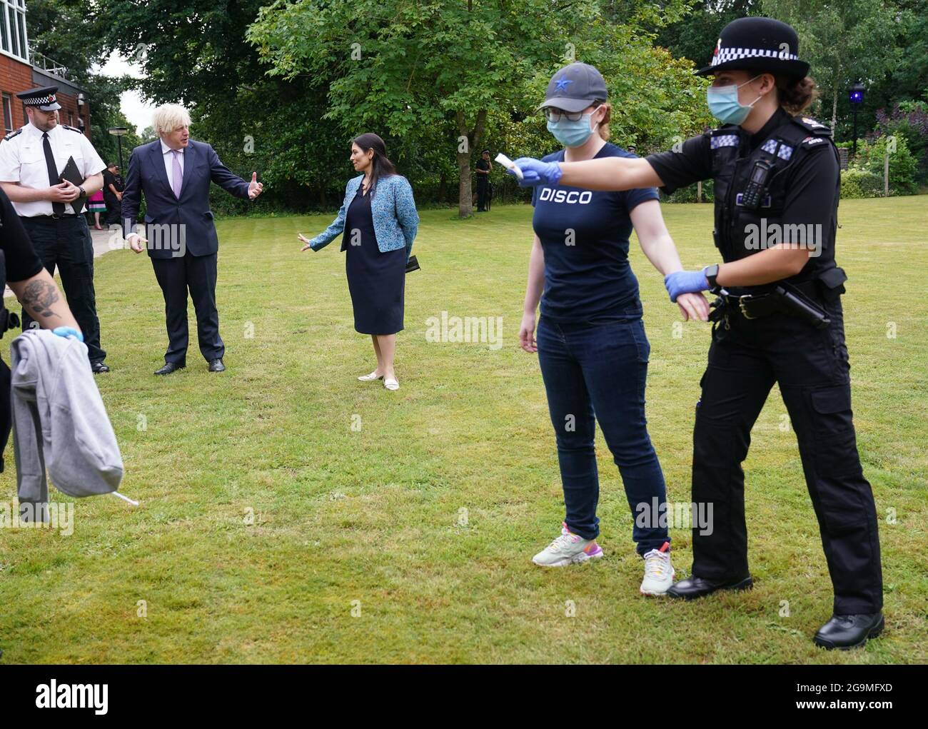 Le Premier ministre Boris Johnson et le secrétaire d'État à l'intérieur, Priti Patel, regardent un exercice de recherche au cours d'une visite au quartier général de la police de Surrey à Guildford, dans le Surrey, pour coïncider avec la publication du Plan de lutte contre le crime du gouvernement. Date de la photo: Mardi 27 juillet 2021. Banque D'Images