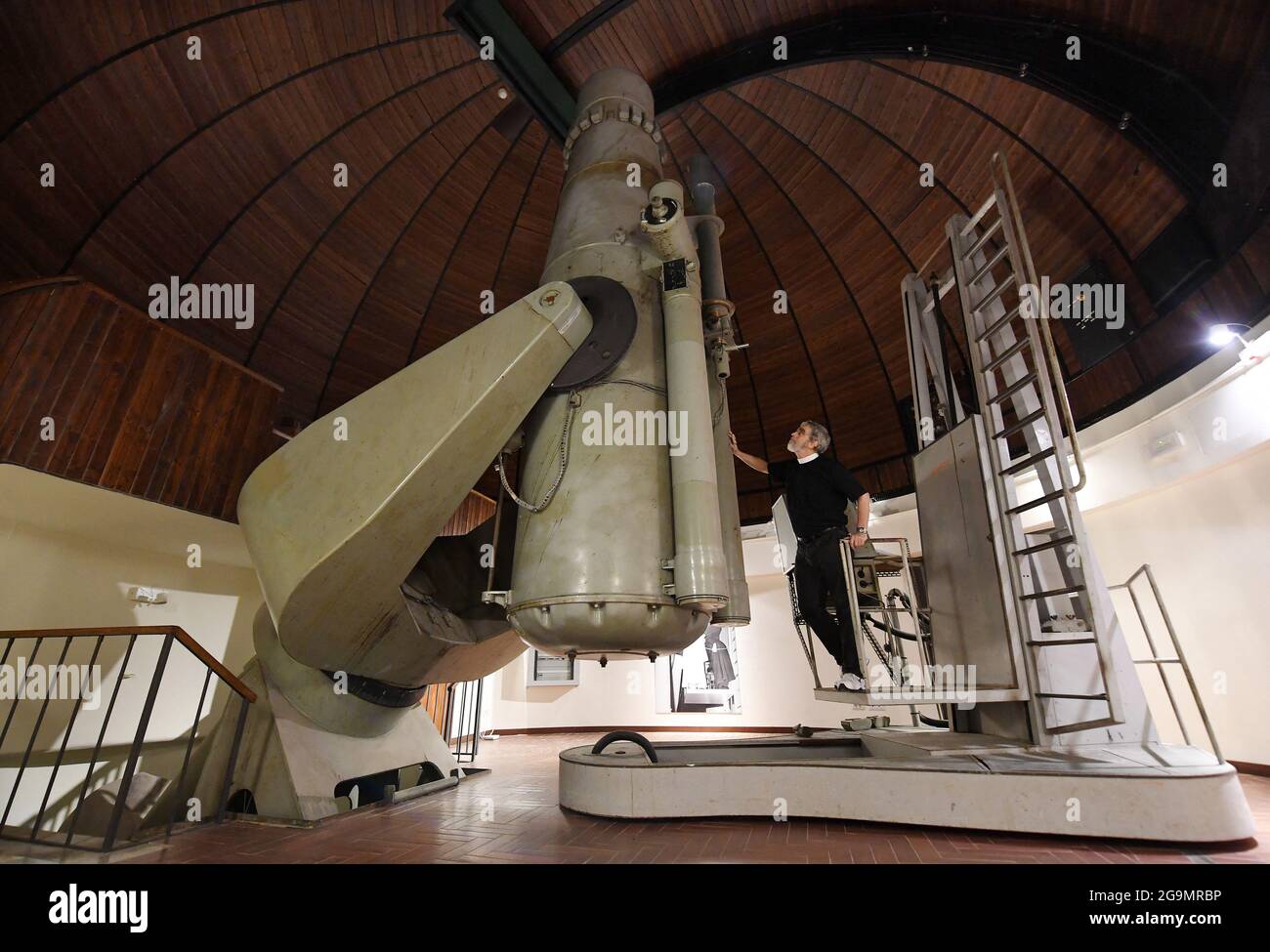 Astronome papal le frère jésuite Guy Consomagno, directeur de l’Observatoire du Vatican depuis 2015, examine à travers le télescope «carte du ciel» un modèle du XIXe siècle avec une focale de 360 cm le 2021 juin au siège de la «Specola Vatican» (Observatoire du Vatican) à Castel Gandolfo, en Italie, le 14 juin, 2021. L'Observatoire du Vatican, l'une des plus anciennes institutions de recherche astronomique du monde, a son siège à la résidence d'été papale de Castel Gandolfo, en dehors de Rome. Pour la première foreshadue de l'Observatoire peut être tracé à la constitution par le Pape Grégoire XIII d'a Banque D'Images