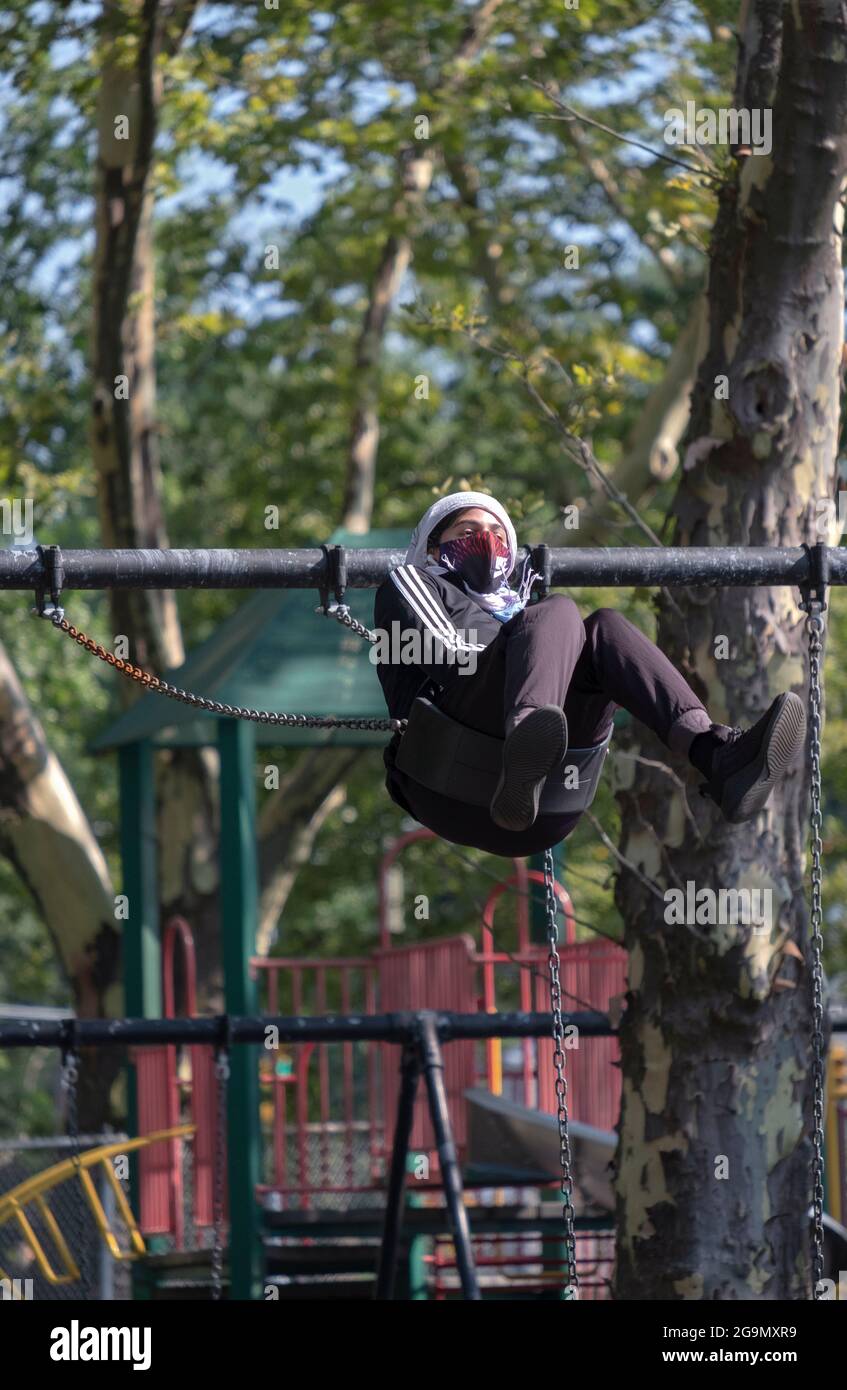 Une personne sur une balançoire volant haut. À Flushing, Queens, New York. Banque D'Images