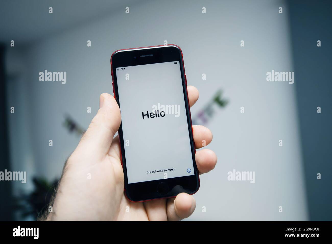 POV main mâle tenant le dernier iPhone se 2e génération smartphone Banque D'Images