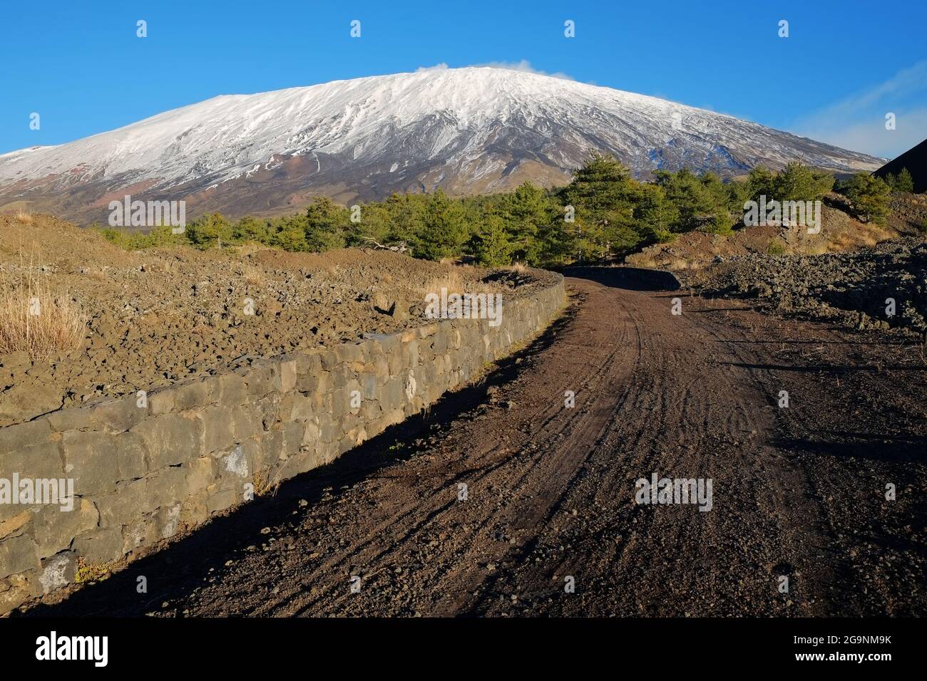 Piste de terre courbe au volcan Etna enneigé, Sicile Banque D'Images