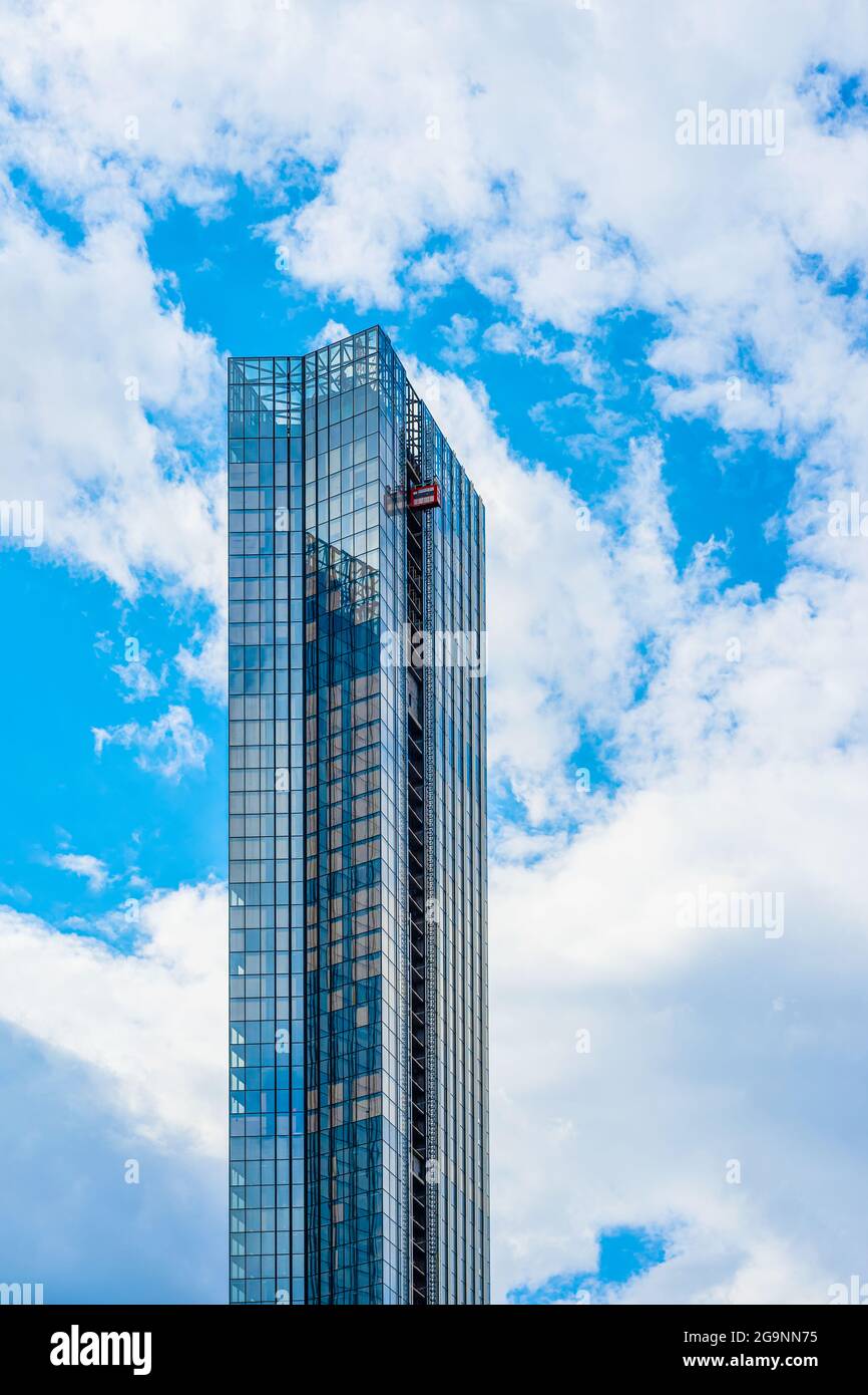 Gratte-ciel haut et moderne en construction contre le ciel bleu. Logement, concept de construction. Arrière-plan vertical, espace de copie Banque D'Images