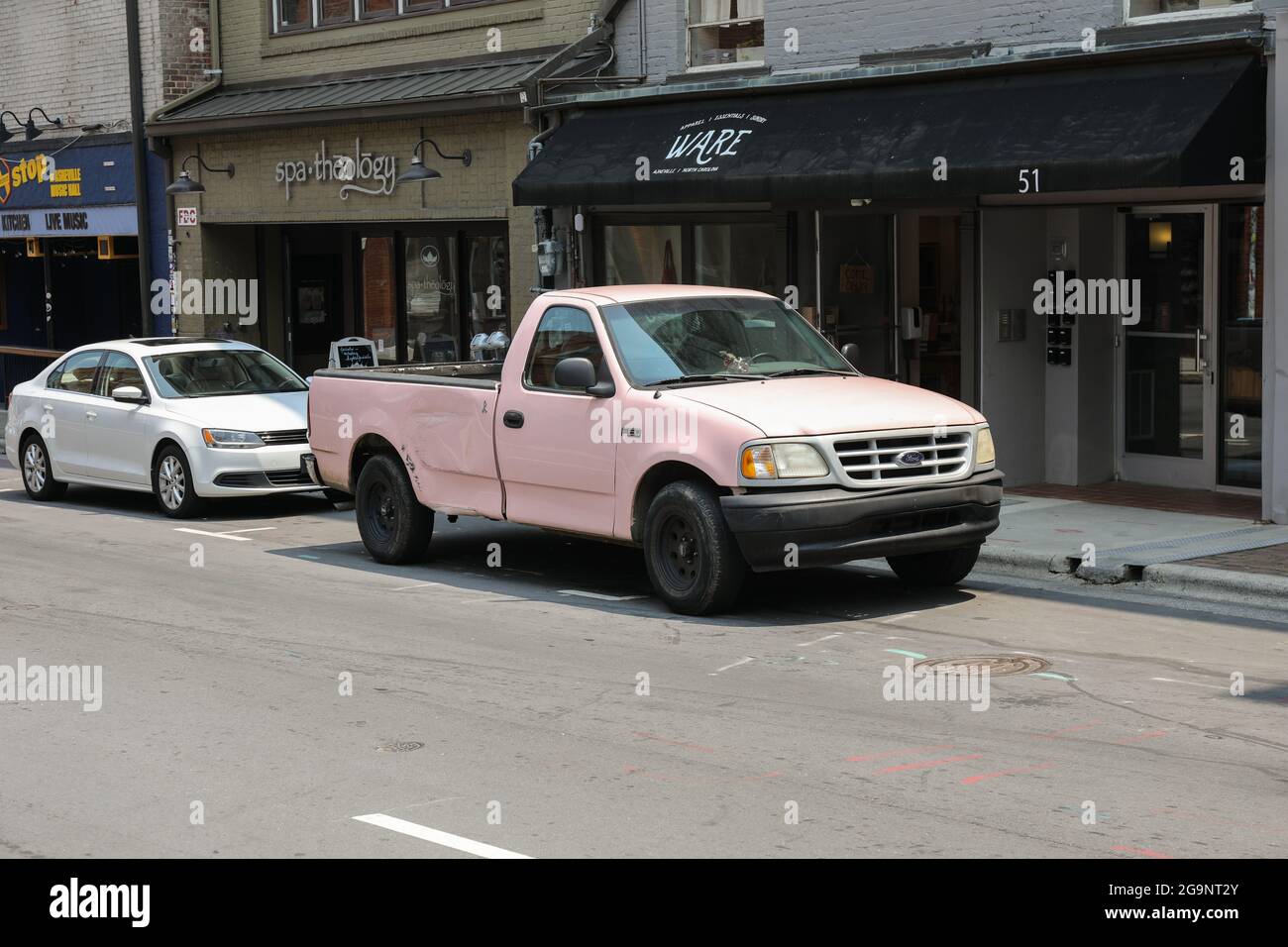 ASHEVILLE, NC, USA-22 JUILLET 2021 : un pick-up rose Ford stationné sur le trottoir. Banque D'Images