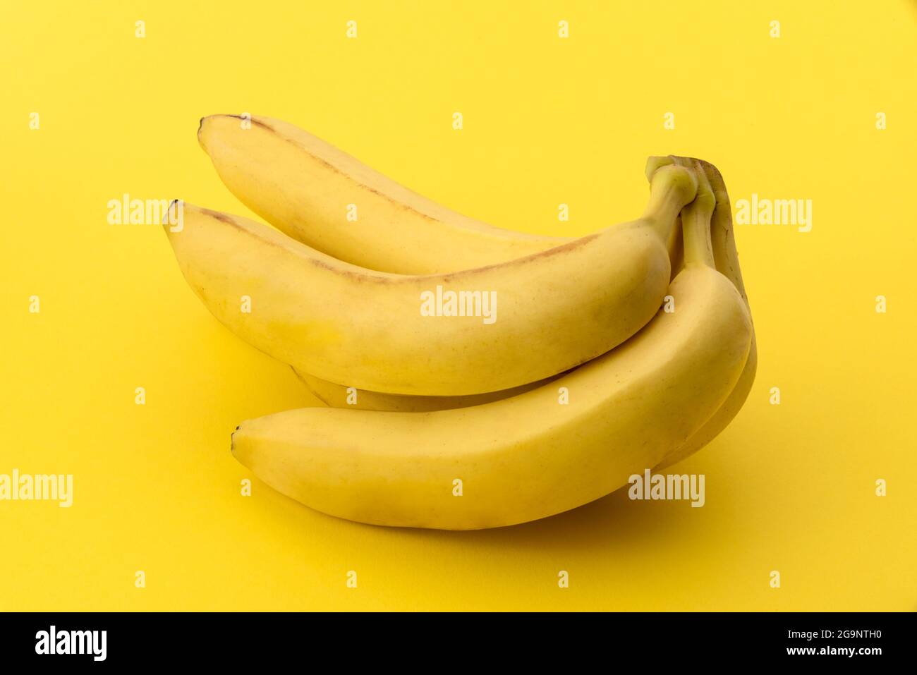 Bouquet de bananes sur fond jaune, espace de copie, graphiques pour étiquette ou carte de vœux Banque D'Images