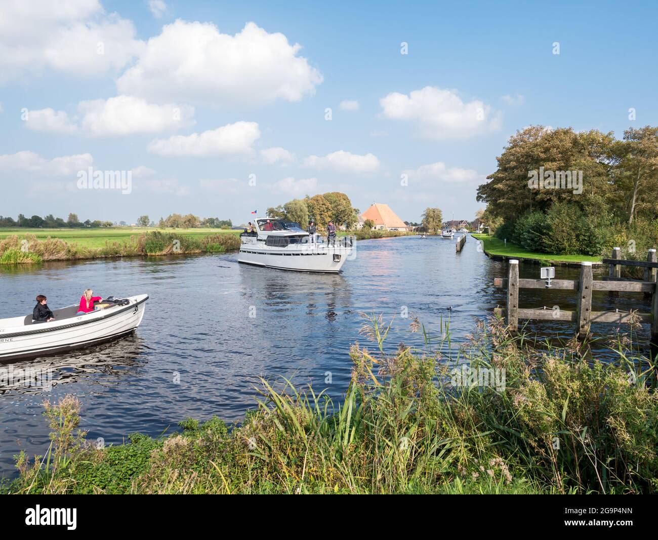 Des personnes sur des yachts à moteur naviguant sur la rivière Boorne à Akkrum, Frise, pays-Bas Banque D'Images