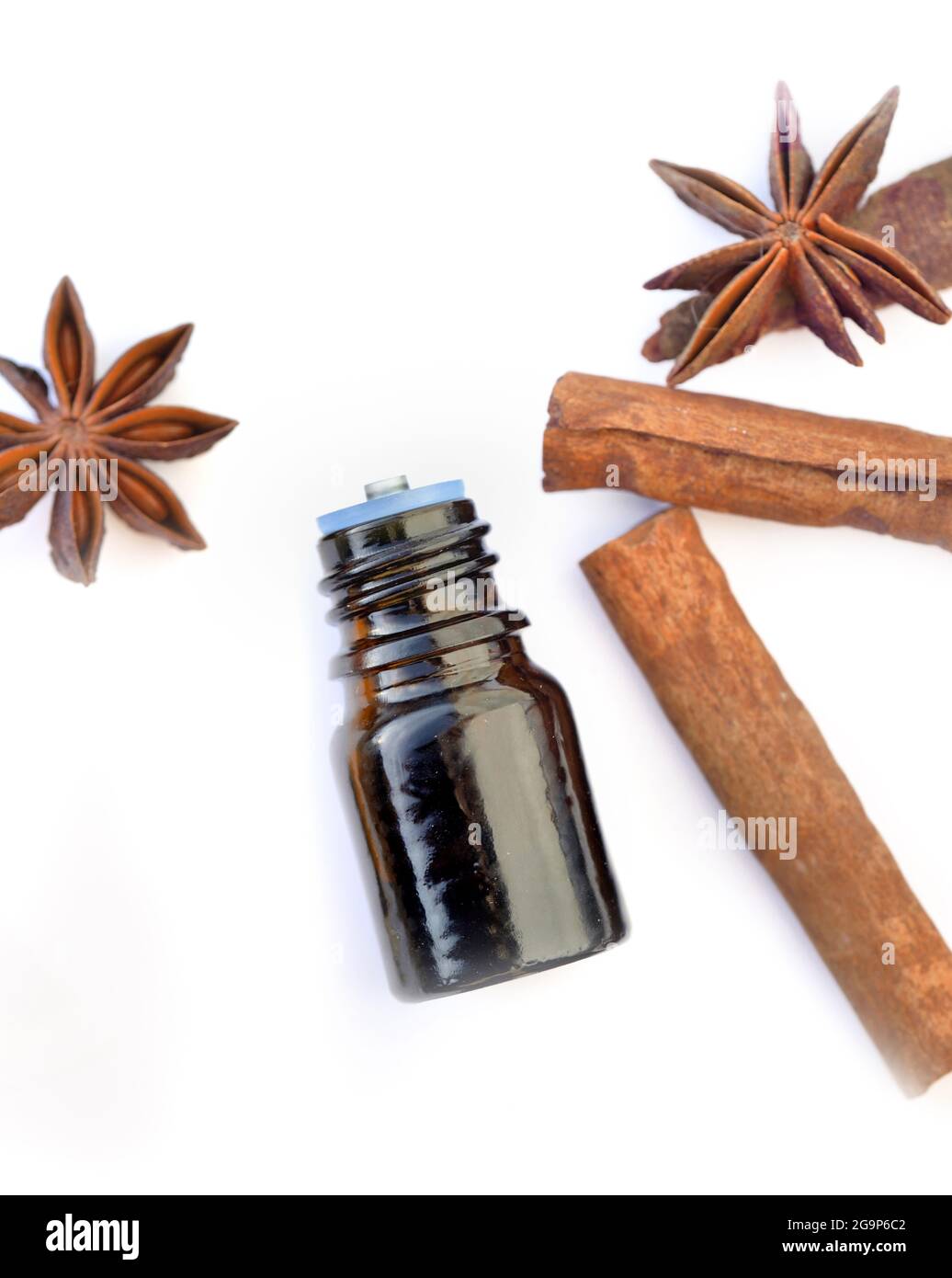 bouteille d'huile essentielle à la cannelle et à l'anis sur fond blanc Banque D'Images