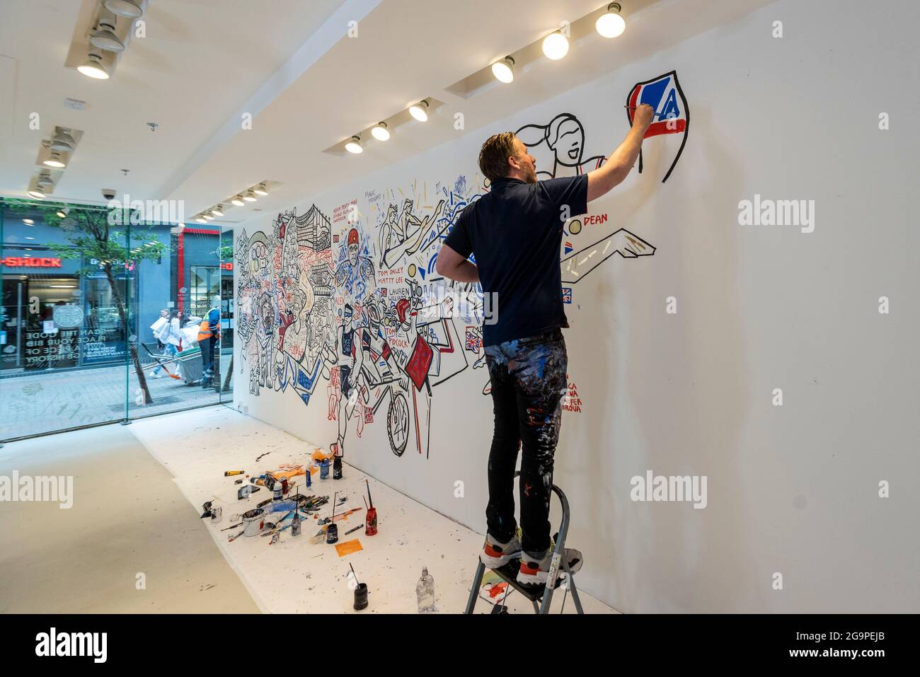 Londres, Royaume-Uni. 27 juillet 2021. Ben Mosley, peintre expressionniste et d'action, crée une fresque murale axée sur la réalisation des athlètes de l'équipe de Grande-Bretagne (GB) aux Jeux Olympiques de Tokyo en 2020. Il travaille actuellement à partir du studio pop-up Team GB à Carnaby Street jusqu'au 8 août, et le travail est mis à jour quotidiennement avec les succès des athlètes. Team GB est devenu le premier à adopter des jetons non fongibles (NFT) présentant les réalisations précédentes des athlètes, qui peuvent être achetés dans un magasin dédié. Credit: Stephen Chung / Alamy Live News Banque D'Images