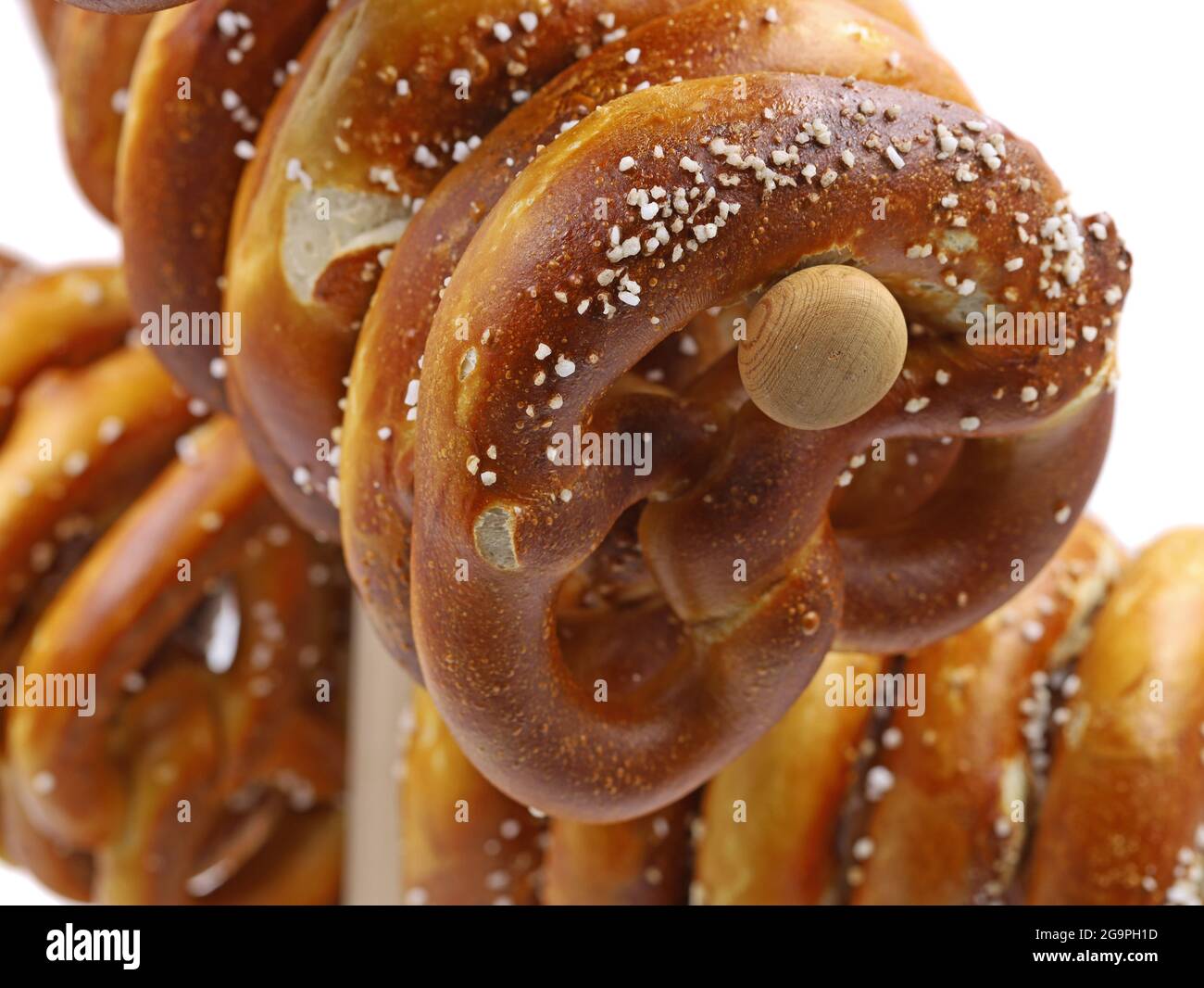 bretzel bavarois fraîchement cuit sur un stand traditionnel en bois isolé sur fond blanc, gros plan Banque D'Images