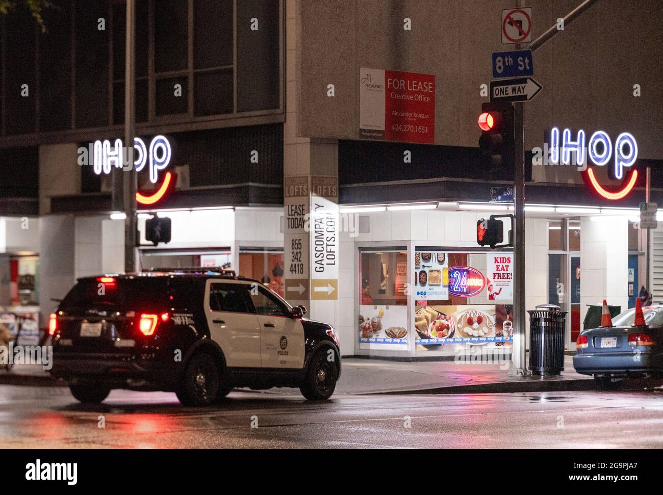 Voiture de police garée près du restaurant IHOP, éclairée la nuit, à l'angle de 8th Street & Flower str, centre-ville de Los Angeles, Californie, États-Unis Banque D'Images