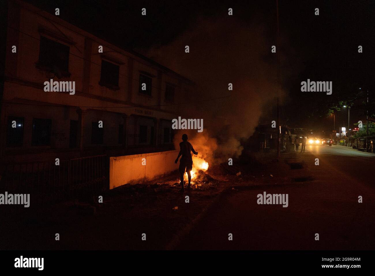 L'homme met le feu sur la rue en Afrique de l'Ouest Banque D'Images