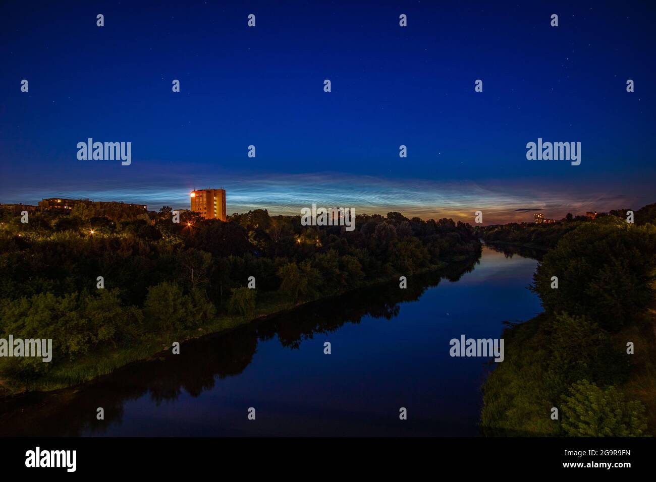 Des nuages Noctilucent au-dessus de la rivière Neris et des arbres Banque D'Images