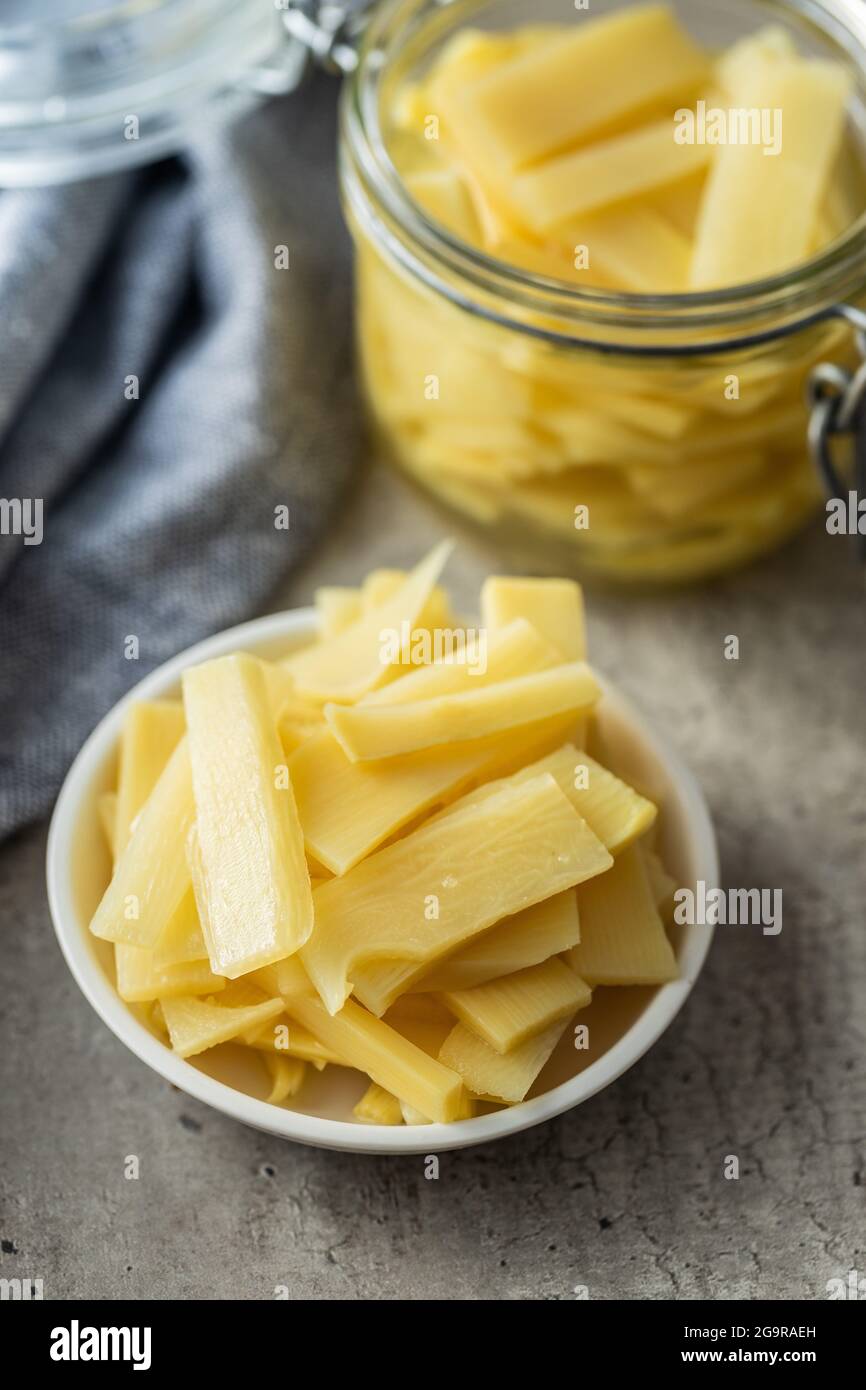 Tranches de pousses de bambou en conserve dans un bol sur une table de cuisine. Banque D'Images