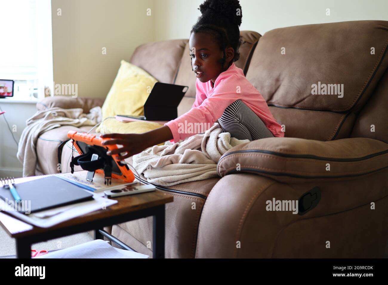 Une fille noire assistant à un cours Zoom ou Equipes à distance pendant la pandémie COVID19 Banque D'Images