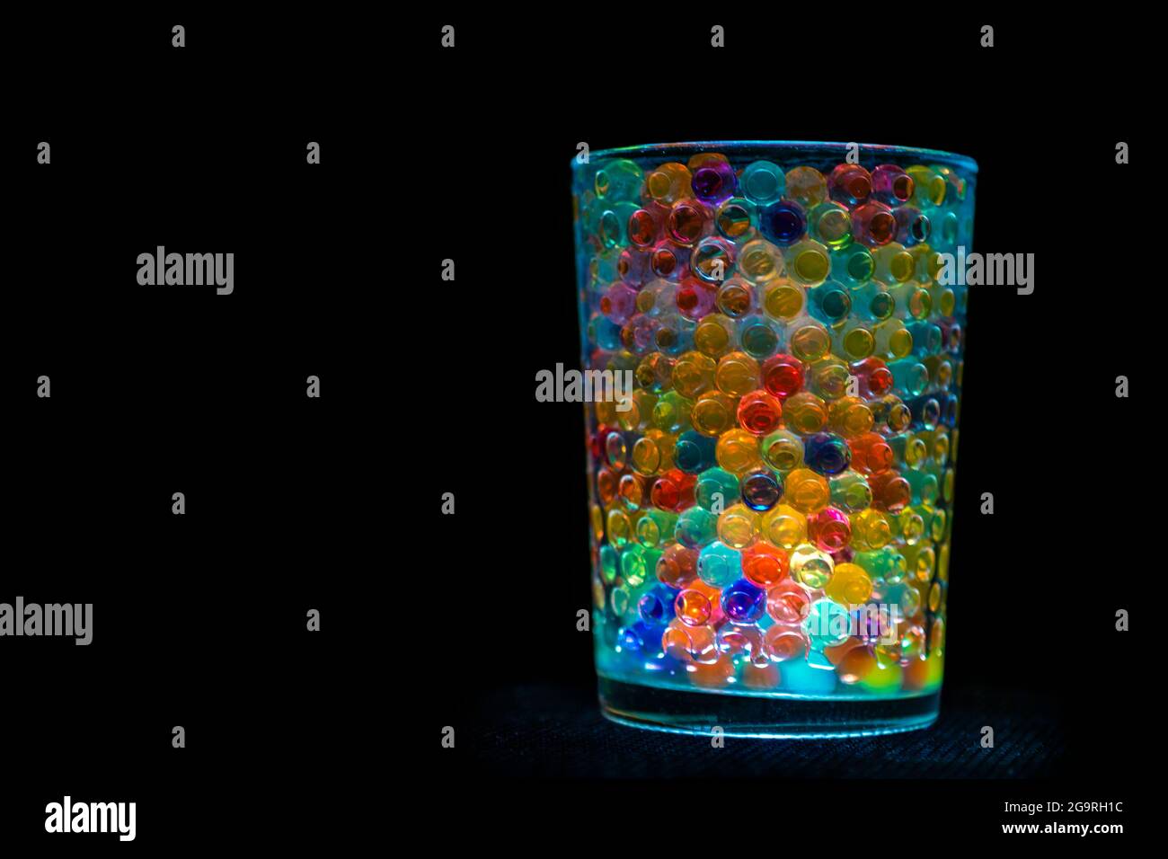 boules multicolores à l'intérieur d'un conteneur transparent et éclairé, donnant une belle image multicolore. Banque D'Images