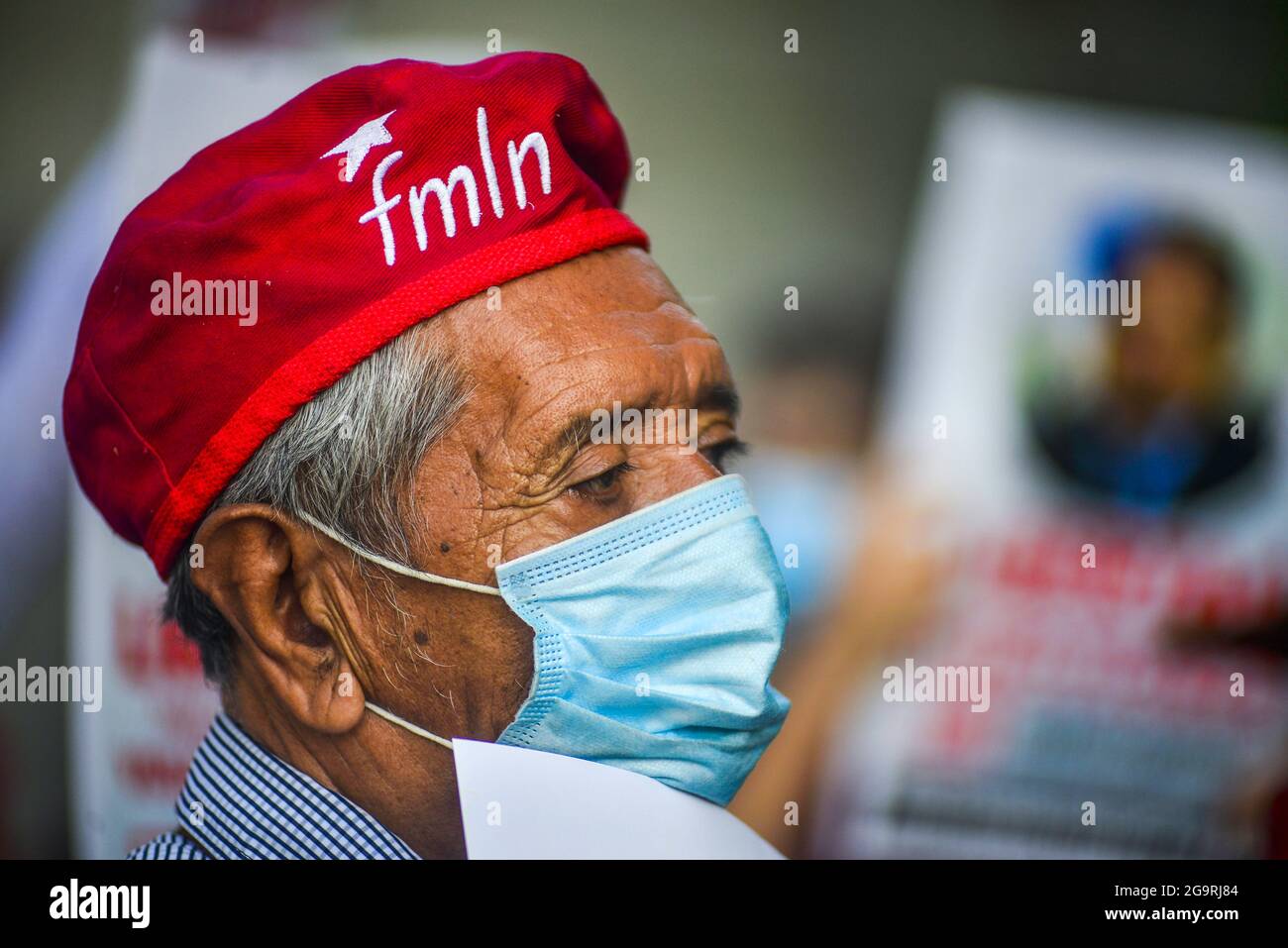 Un homme portant un béret montrant des images du FMLN regarde pendant une protestation contre l'arrestation. Le bureau du procureur général a arrêté cinq anciens fonctionnaires du premier gouvernement du FMLN (Frente Farabundo Martí para la Liberación Nacional), tandis que cinq autres, dont l'ancien vice-président, Sanchez Cerén, sont recherchés mais n'ont pas encore été arrêtés. Les dirigeants du FMLN et les mouvements de défense des droits de l'homme ont qualifié cela d'emprisonnement politique, citant le fait que la procédure régulière n'était pas garantie et le procureur général qui a pris ses fonctions après que le parti du président Nayib Bukele au Congrès ait évincé l'ATT constitutionnel Banque D'Images