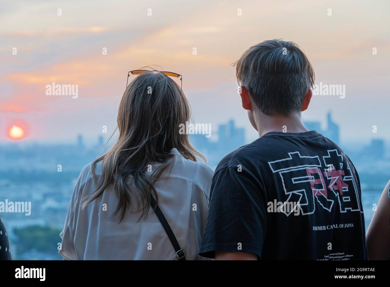 Paris, France - 07 22 2021: La Tour Eiffel: Une jeune fille et un garçon regardant la vue de Paris depuis la Tour Eiffel au coucher du soleil Banque D'Images