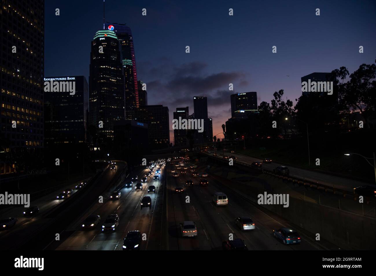 Los Angeles, CA USA - février 7 2020 : trafic sur la Harbour Freeway à travers le centre-ville de Los Angeles au coucher du soleil Banque D'Images